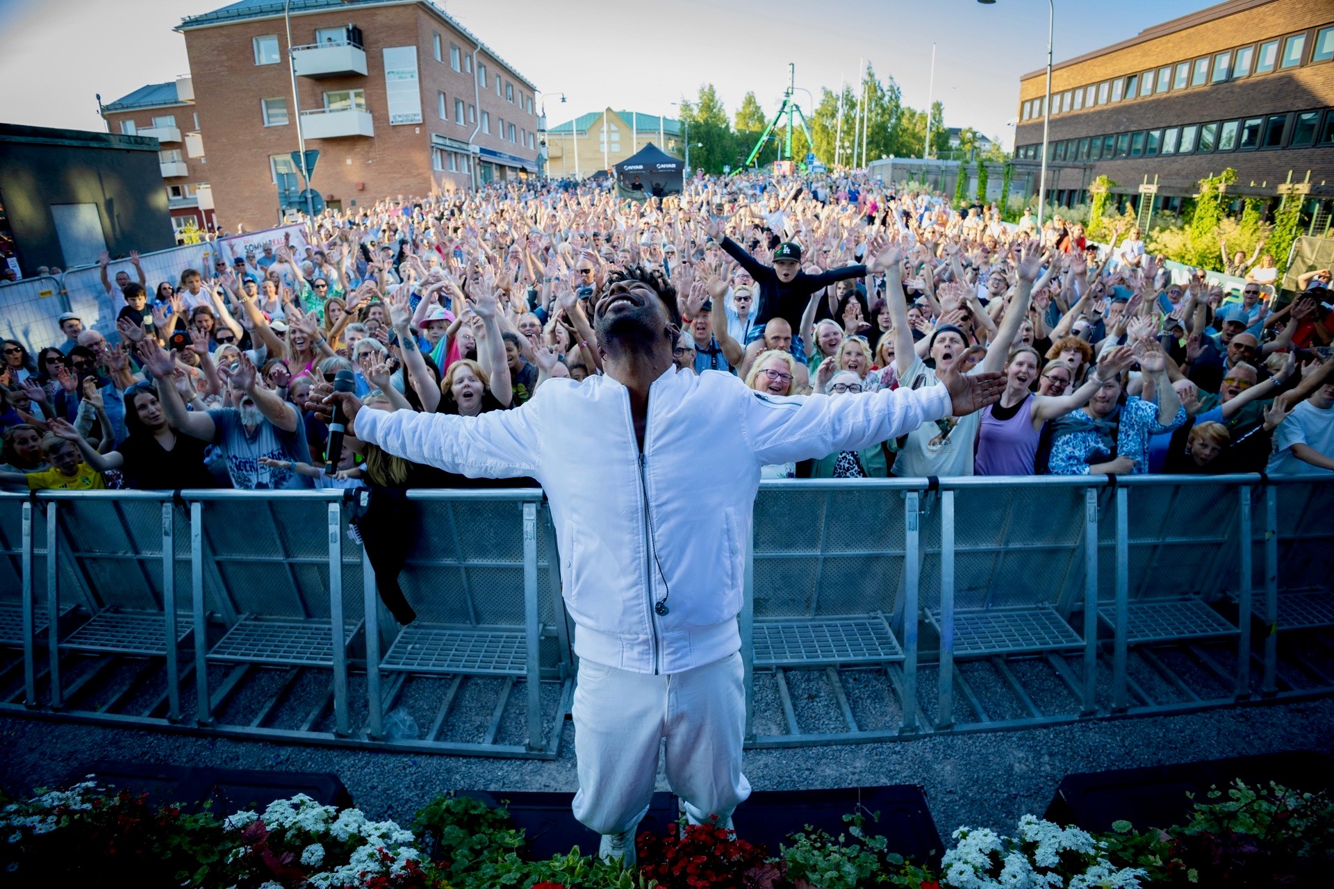 Sommarkalaset 2025.: artisten John Lundvik med utsträckta armar och ett helt publikhav i bakgrunden.